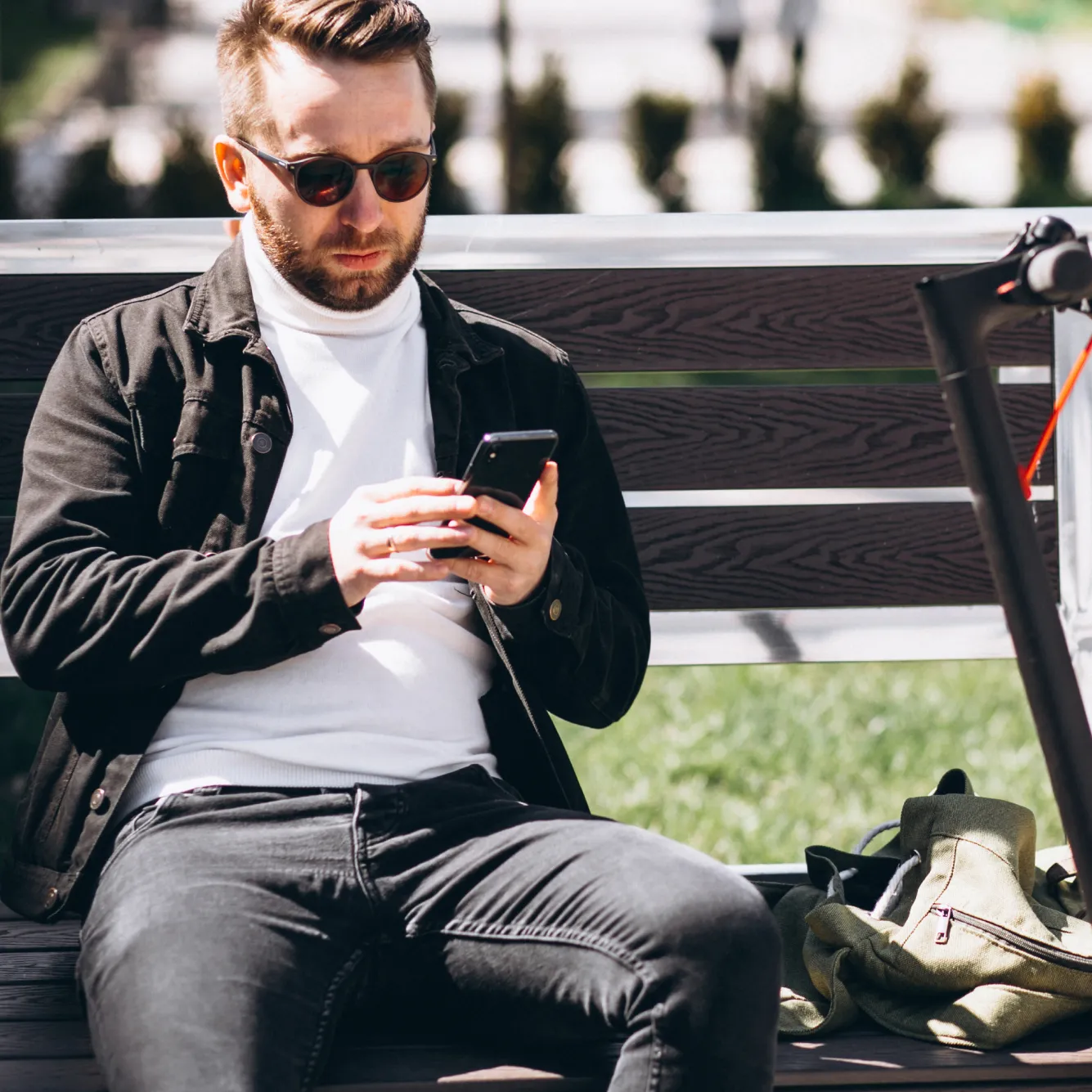 Trader in sunglasses using smartphone to trade Step Indices on Deriv while sitting on park bench